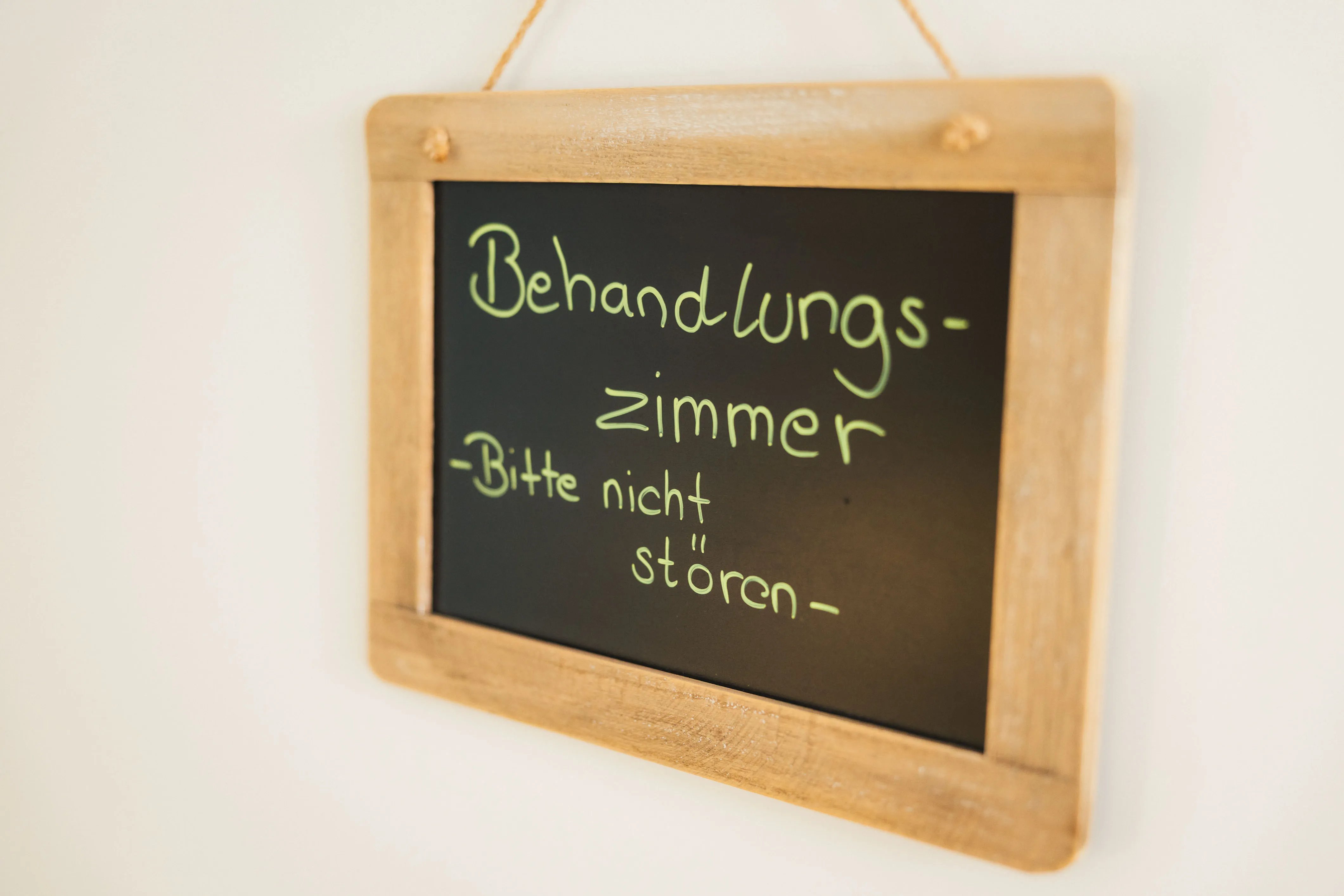 Handbeschriebene Kreidetafel an der Tür: Behandlungszimmer, bitte nicht stören